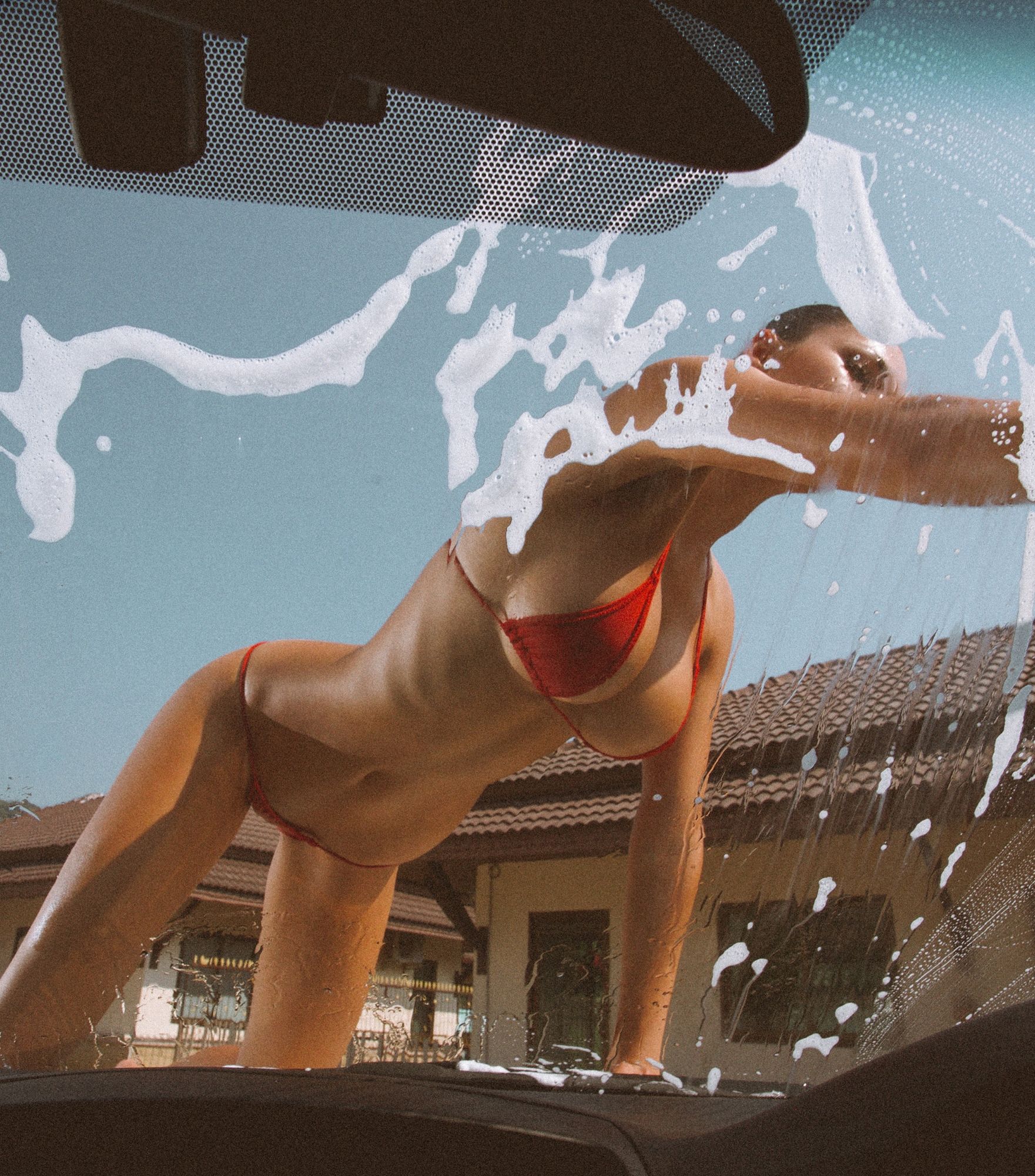 Hot girl in red bikini washing a car window